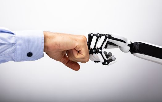 A human hand and robotic hand fist-bumping to celebrate harnessing the power of robotics for legal firms
